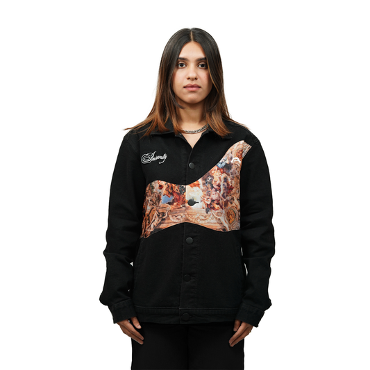 A female model wearing a black denim jacket with a printed artistic design on the front panel and white embroidered text "Insanity." She is adjusting the jacket while wearing a black crop top underneath.